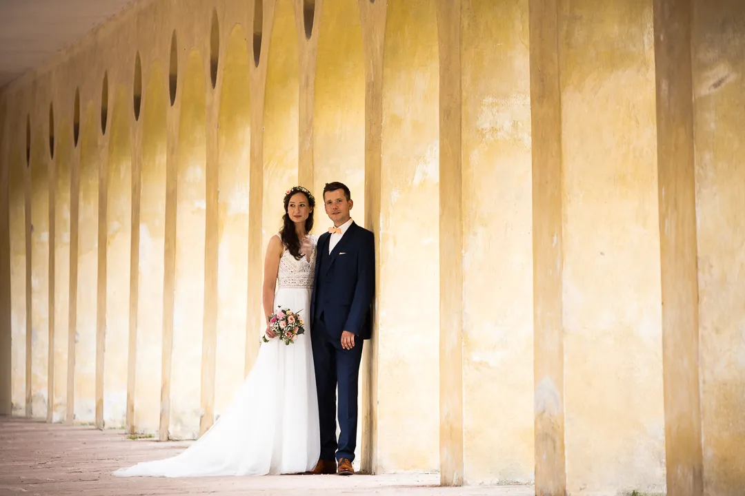 Hochzeitsfoto in Rastatt: Brautpaar unter den Arkaden am Schloss Favorite